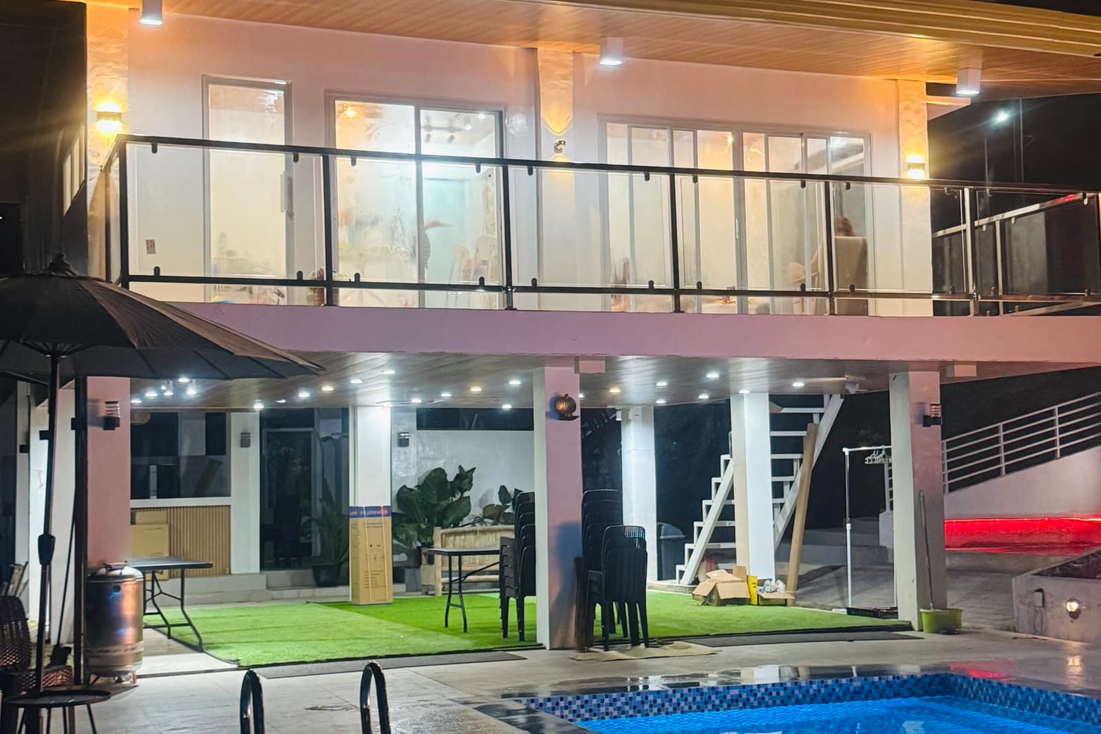 Open-air al fresco kitchen and lounge area at night