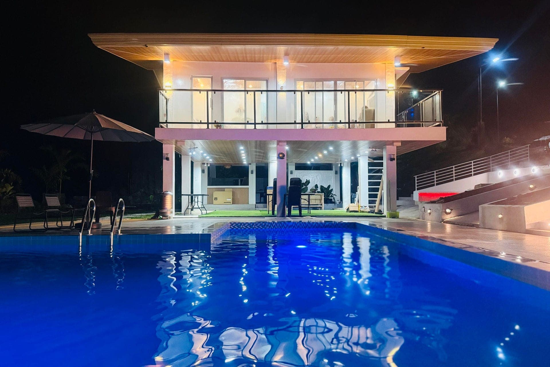 Lilee's Farm Resort villa and swimming pool illuminated at night